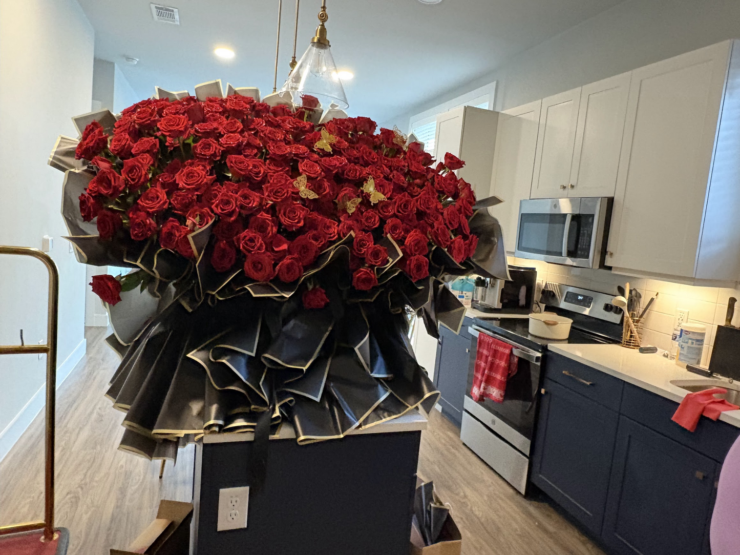 Alternate angle of a super giant 200 premium red rose bouquet with black and gold wrapping