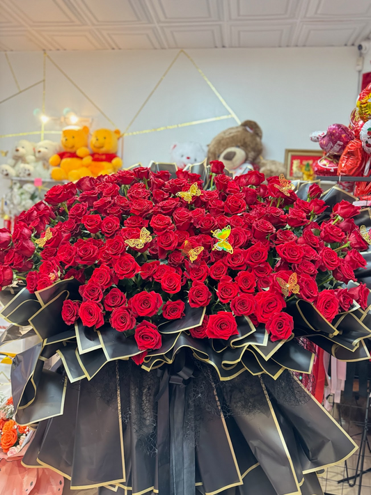 Front view of a super giant bouquet made with 200 premium red roses in black and gold wrapping
