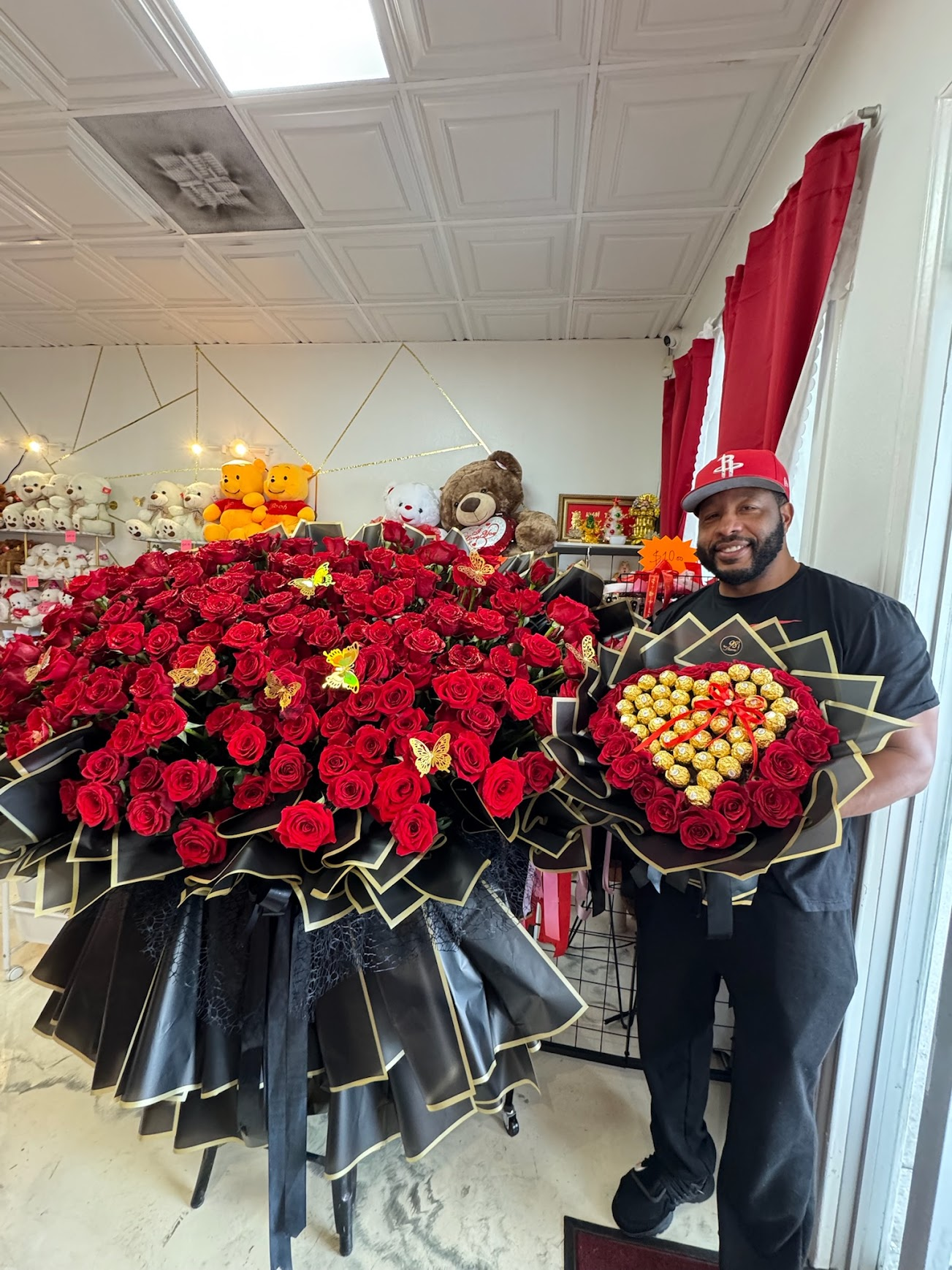 Customer standing beside a super giant 200 red rose bouquet showing its impressive scale