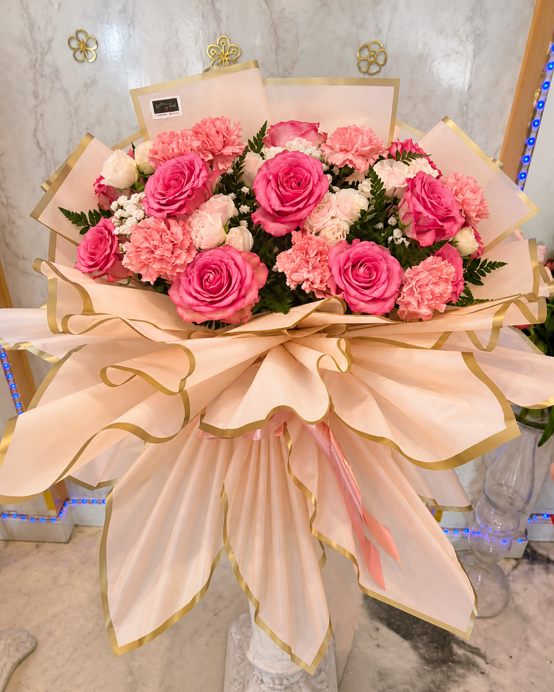 Pink rose and carnation bouquet in blush wrapping with gold trim