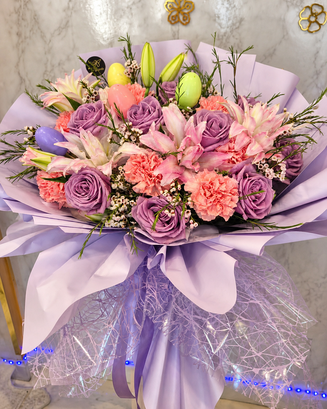 Lavender rose, pink lily and carnation Easter bouquet with decorative eggs
