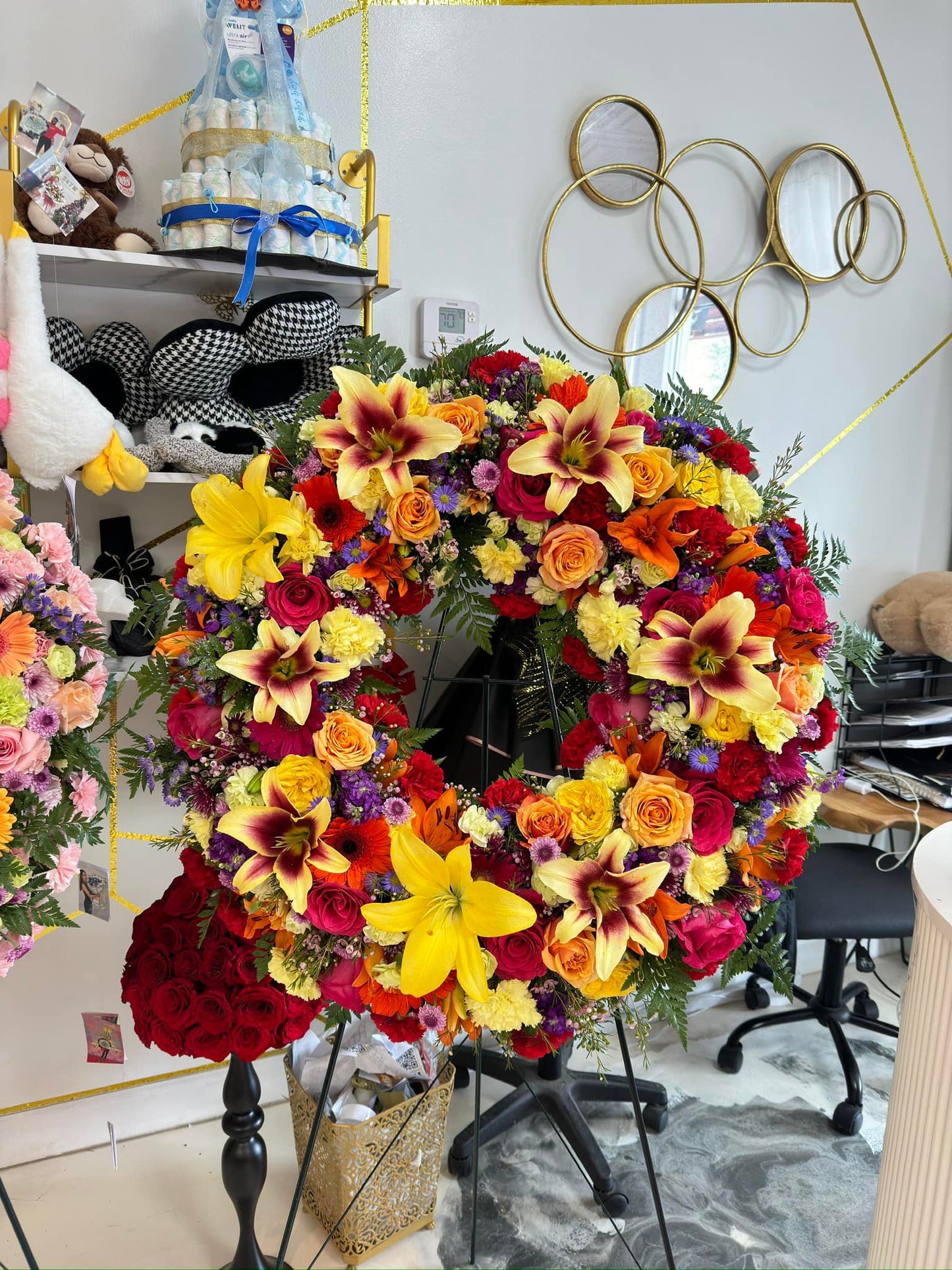 Vibrant celebration of life standing wreath with yellow lilies and red-orange roses