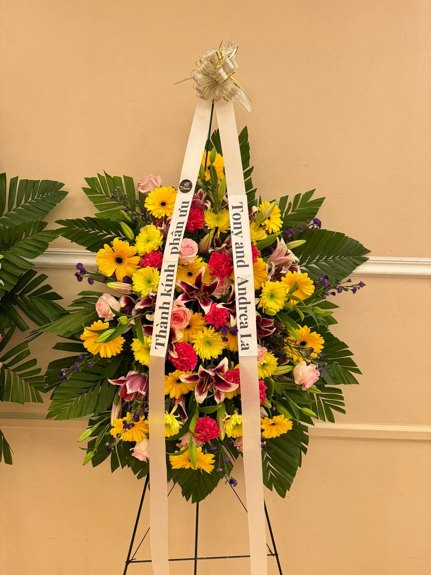 Yellow sympathy standing spray with gerbera daisies, lilies and pink roses by 98 Flowers Houston