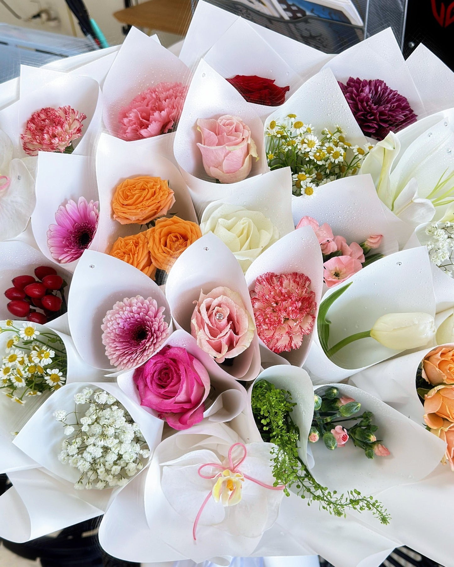 Close-up of 24 individually wrapped mini bouquets in a multicolor flower arrangement