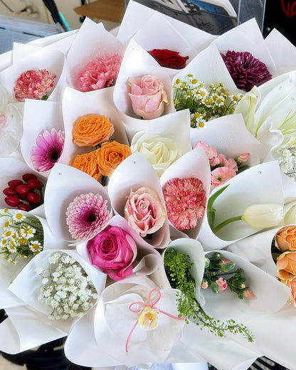 Close-up of 24 individually wrapped mini bouquets in a multicolor flower arrangement