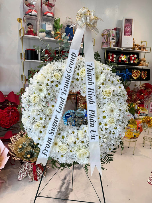 All-white sympathy standing wreath with roses and long condolence ribbon