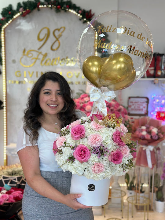 Customer holding a pink and white flower box at 98 Flowers