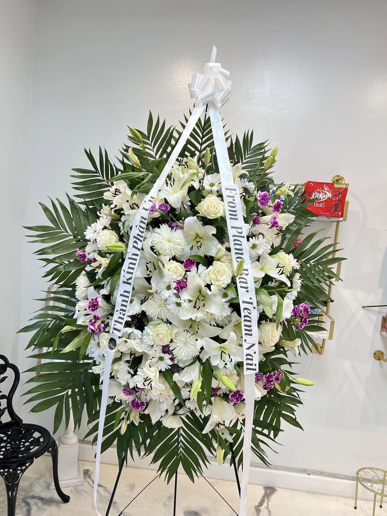 White and soft purple sympathy standing spray with lilies and roses