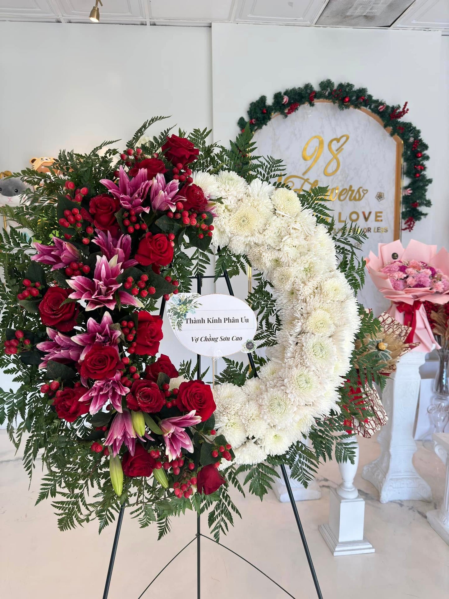 Red and white contrast sympathy wreath with pink lilies and roses