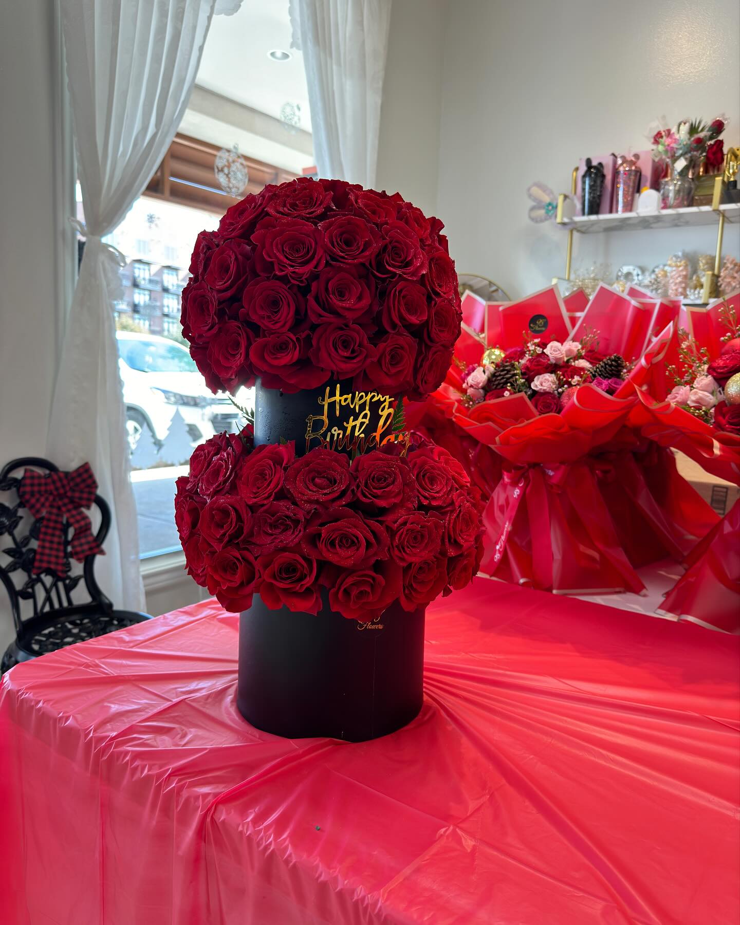 Full-length two-tier red rose tower with a customizable gold message plate