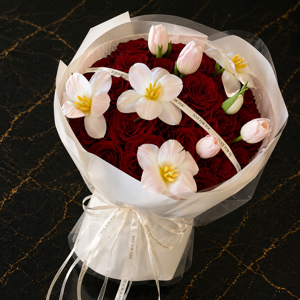 Red rose and blush tulip bouquet with ivory accent flowers and white wrapping