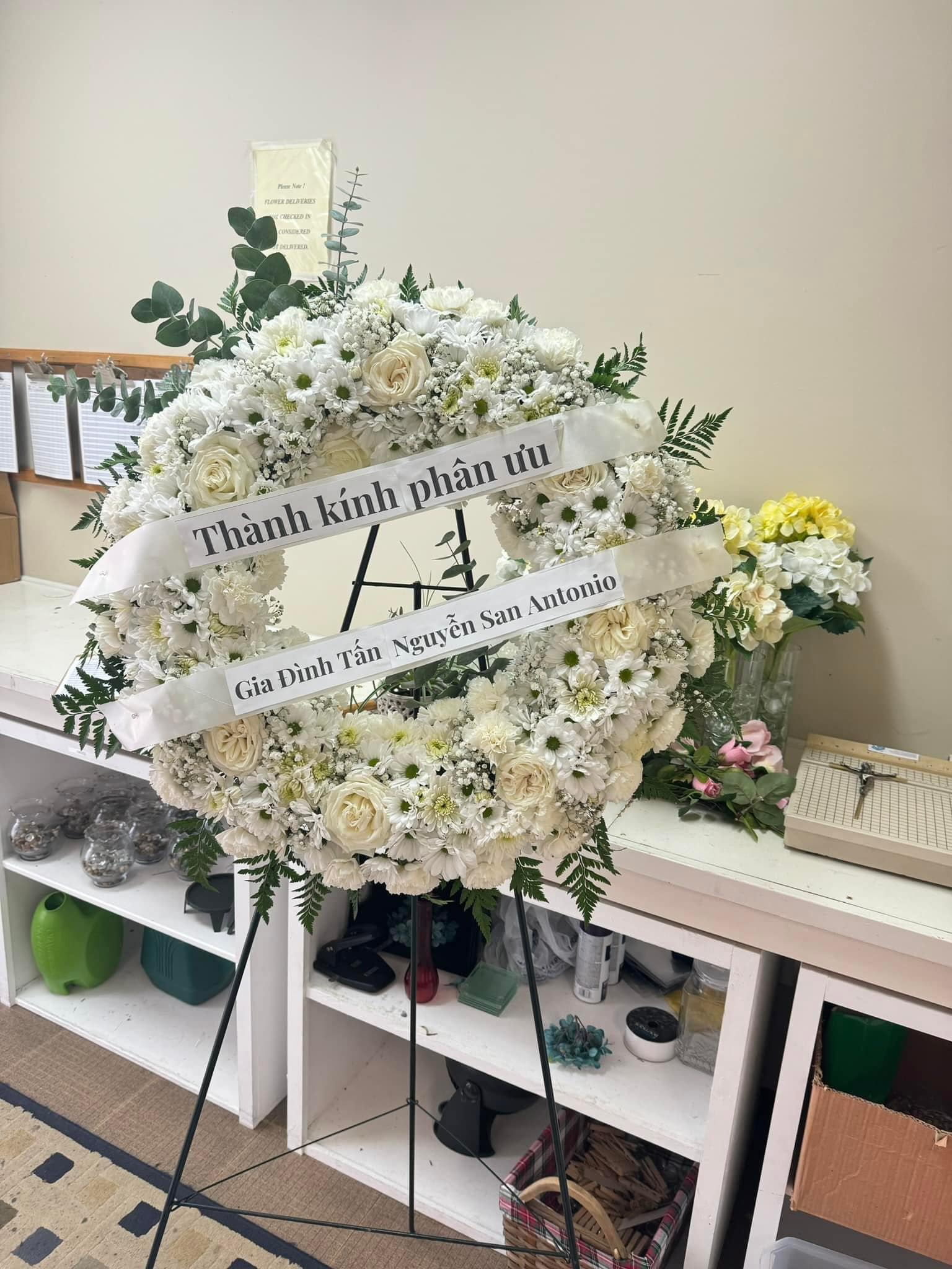 Classic white sympathy standing wreath with roses and condolence banner