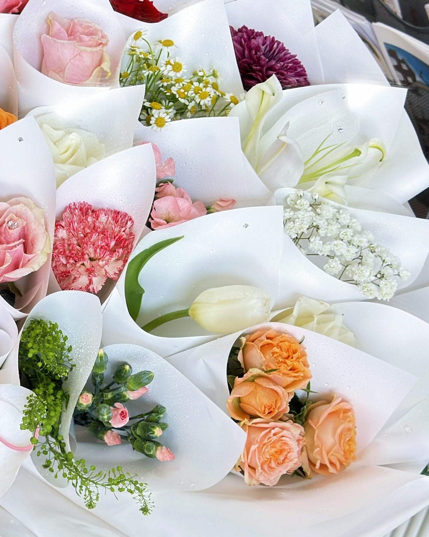 Close-up of pink, orange, white, and purple flowers in individual mini wraps