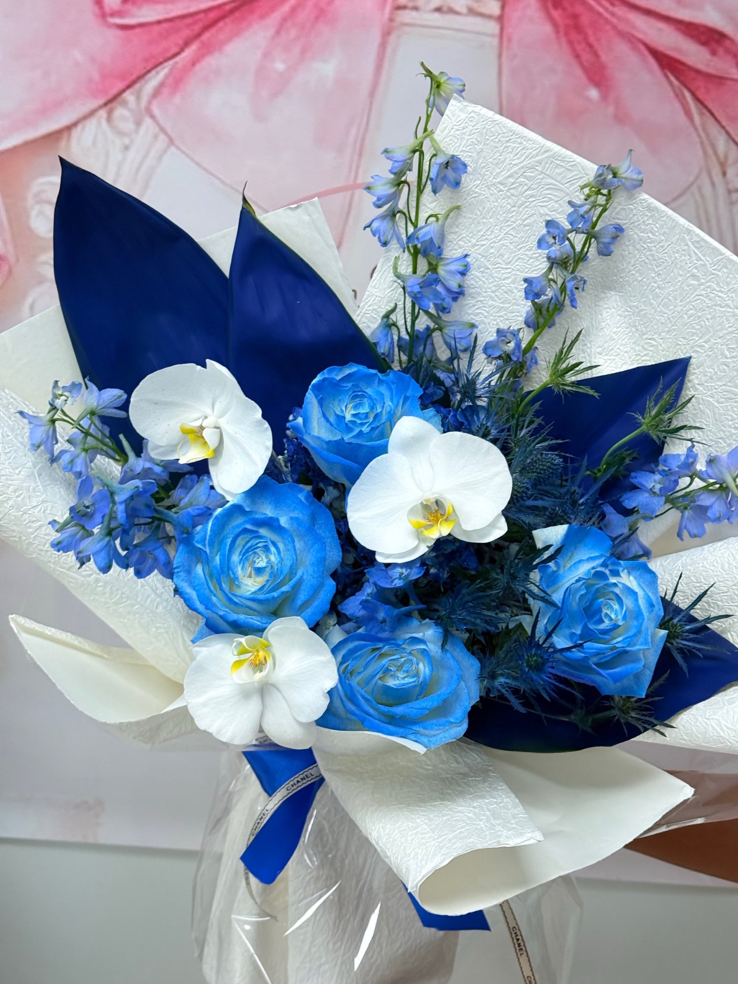 Close-up of blue roses, white orchids, and blue delphinium