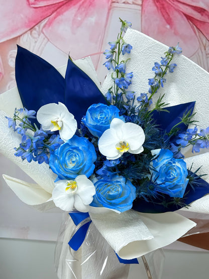 Close-up of blue roses, white orchids, and blue delphinium