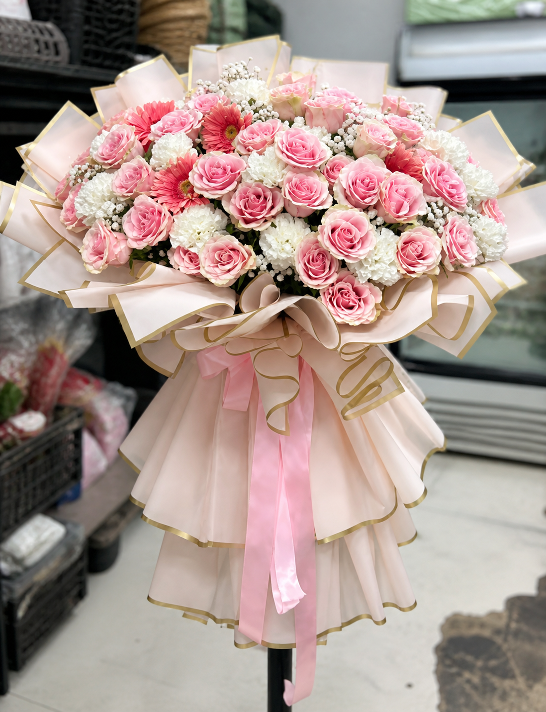 Oversized blush pink and white rose bouquet with gold-trimmed wrapping