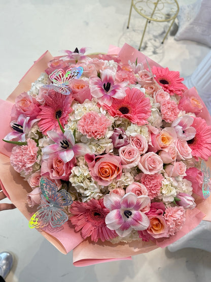 Close-up of a giant pink mixed flower bouquet with butterfly decorations