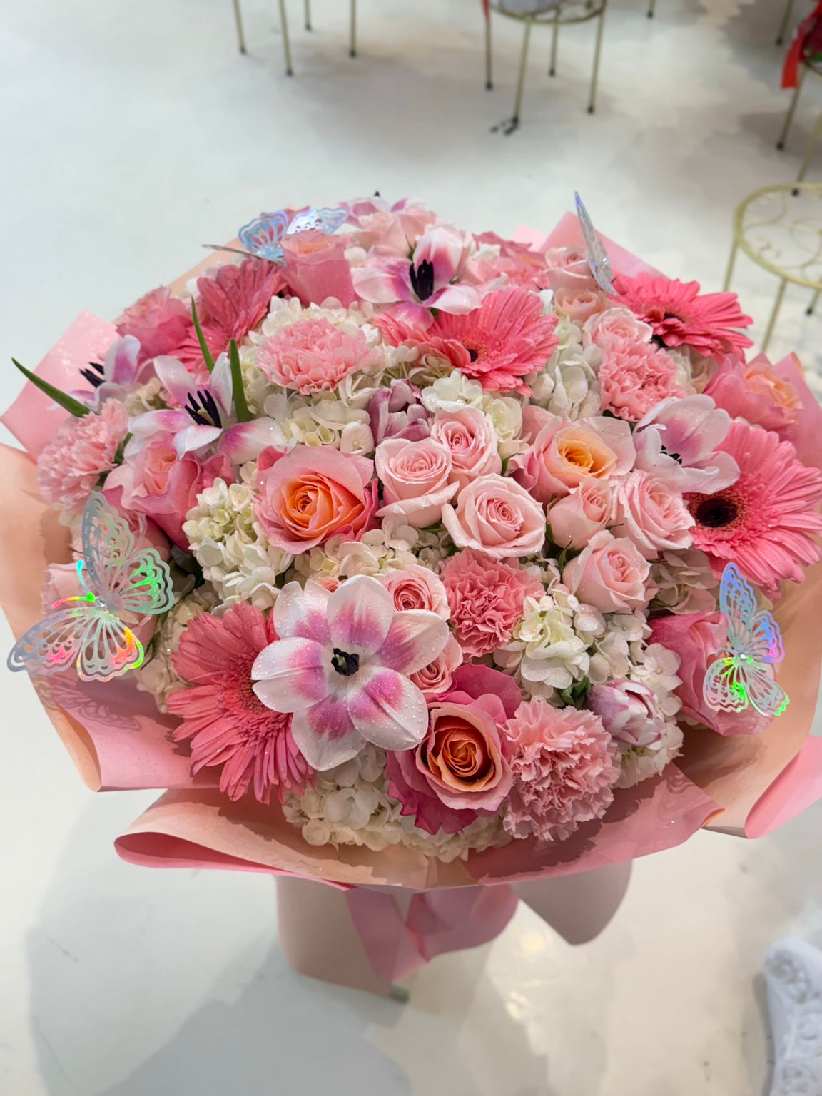 Giant pink fresh flower bouquet with roses, hydrangeas, lilies, carnations, gerbera daisies, and butterfly accents
