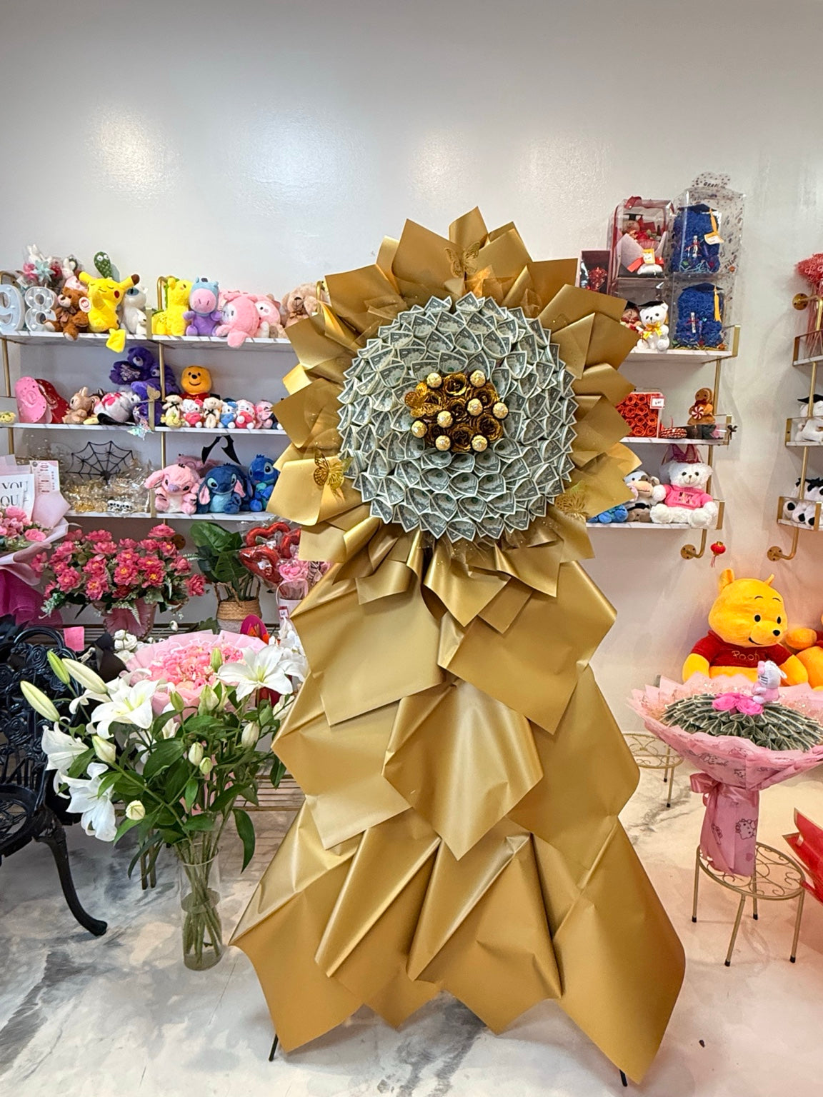 Golden jumbo money flower stand with $100 cash and chocolate centerpiece