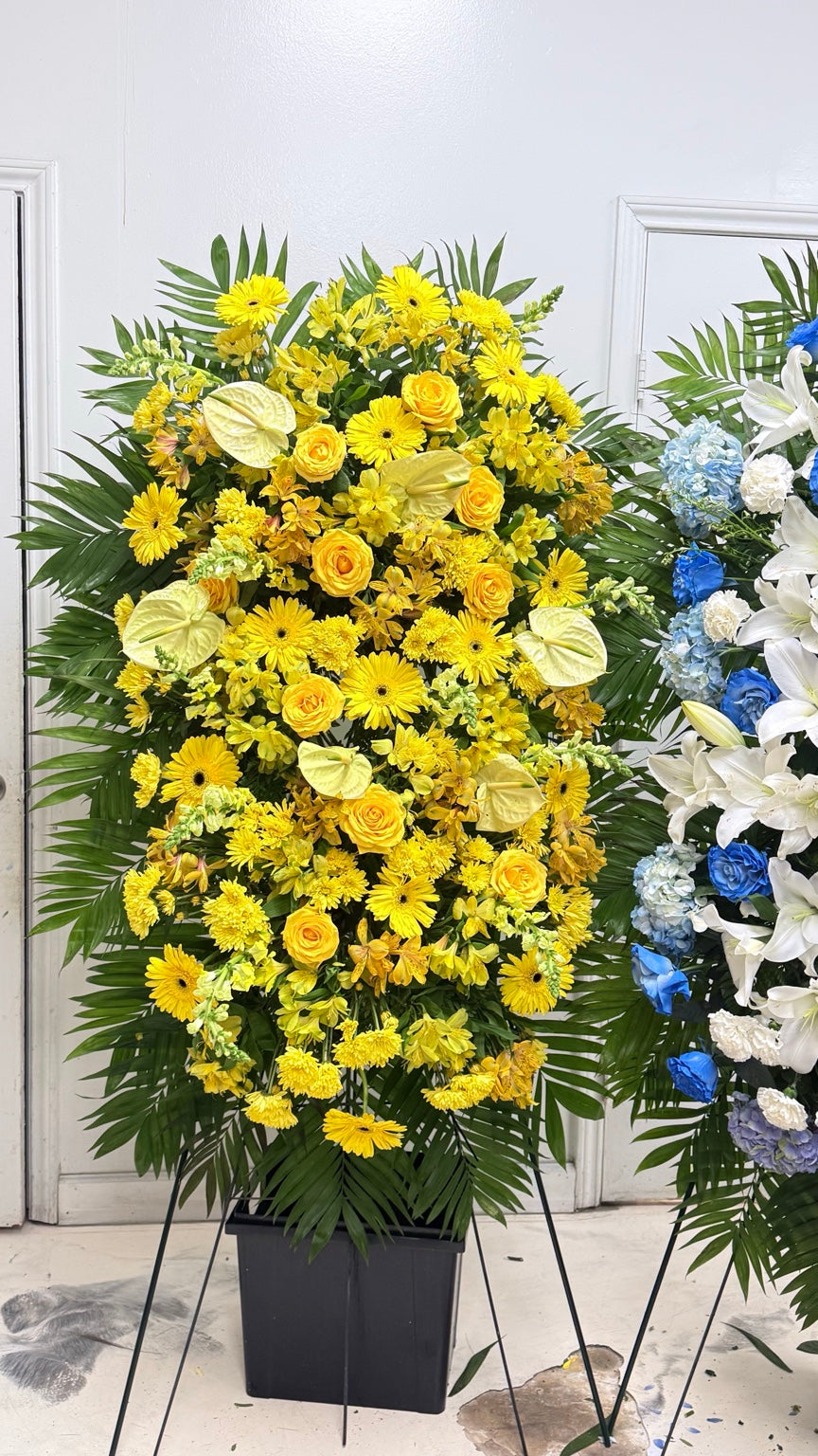 Grand yellow sympathy standing spray with roses, gerberas and tropical greenery