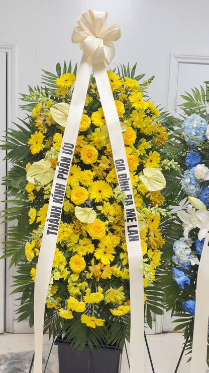 Yellow sympathy standing spray displayed with memorial ribbon