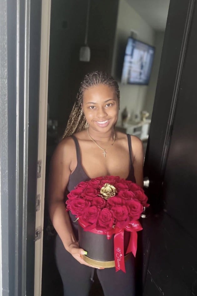 Recipient holding the Golden Kiss red rose box for an all-occasion flower gift